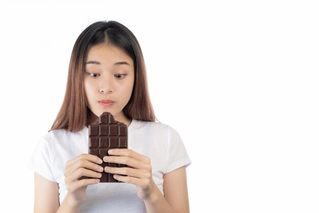 Bella donna con un sorriso felice che tiene una mano cioccolato isolato su uno sfondo bianco.