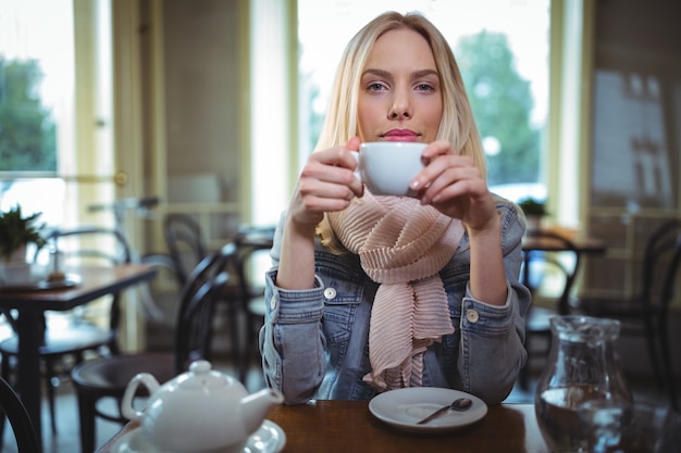 Bella donna con una tazza di caffè in caffetteria ©