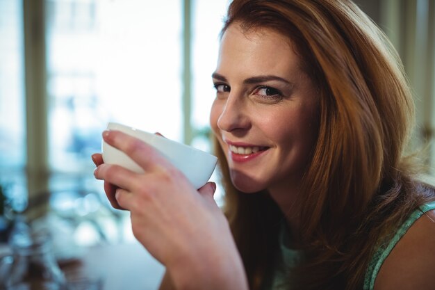 Bella donna con una tazza di caffè in caffetteria ©