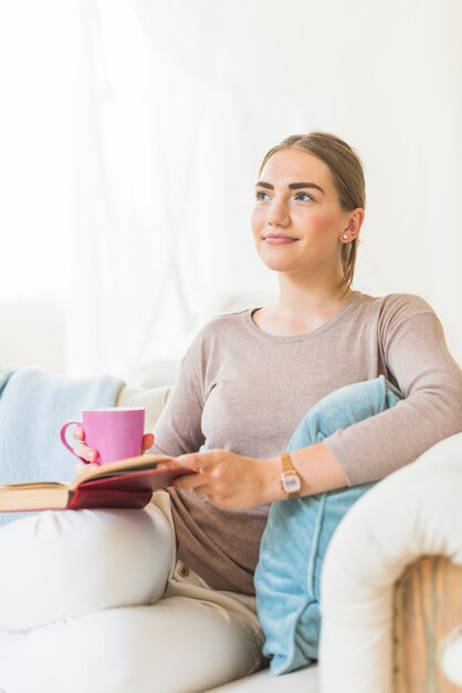 Bella donna contemplata che si distende sul sofà