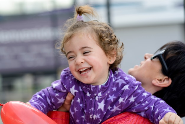 Bella donna e la sua piccola figlia sveglia divertendosi.