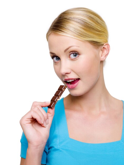 Bella donna felice con una fetta di cioccolato nero - isolato su bianco