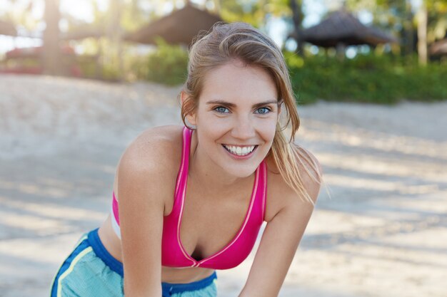 Bella donna in abiti sportivi sulla spiaggia