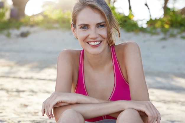 Bella donna in abiti sportivi sulla spiaggia