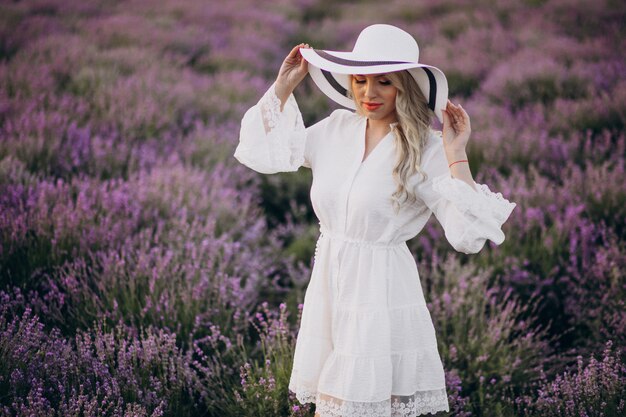 Bella donna in abito bianco in un campo di lavanda