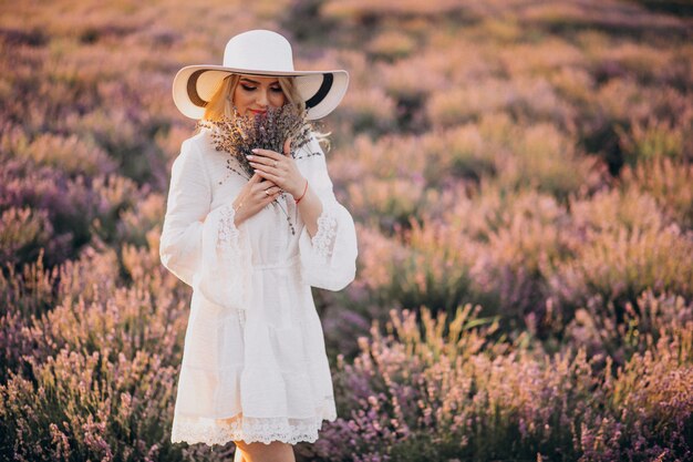 Bella donna in abito bianco in un campo di lavanda