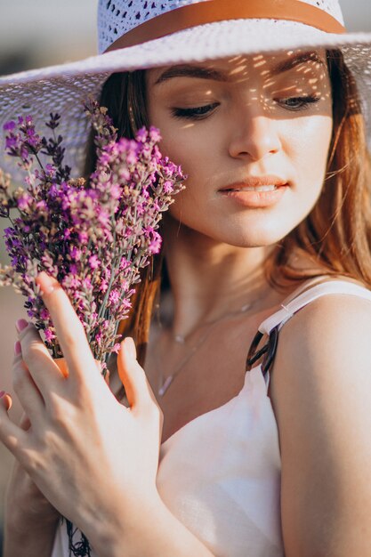 Bella donna in abito bianco in un campo di lavanda