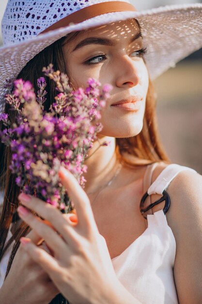 Bella donna in abito bianco in un campo di lavanda