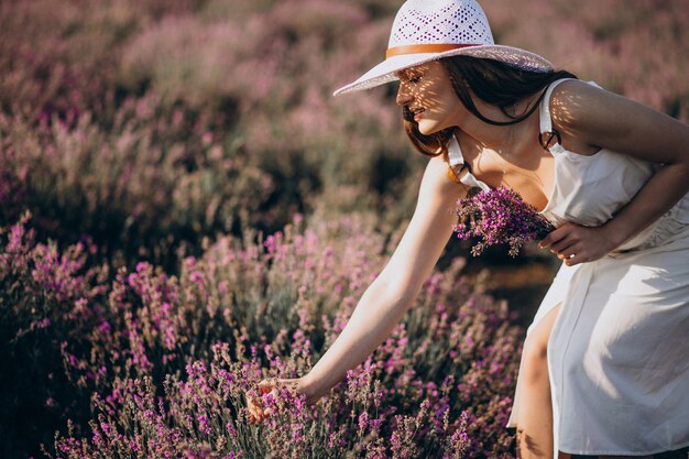 Bella donna in abito bianco in un campo di lavanda