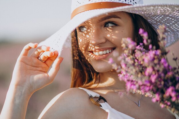 Bella donna in abito bianco in un campo di lavanda