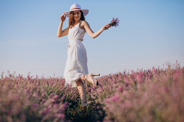 Bella donna in abito bianco in un campo di lavanda