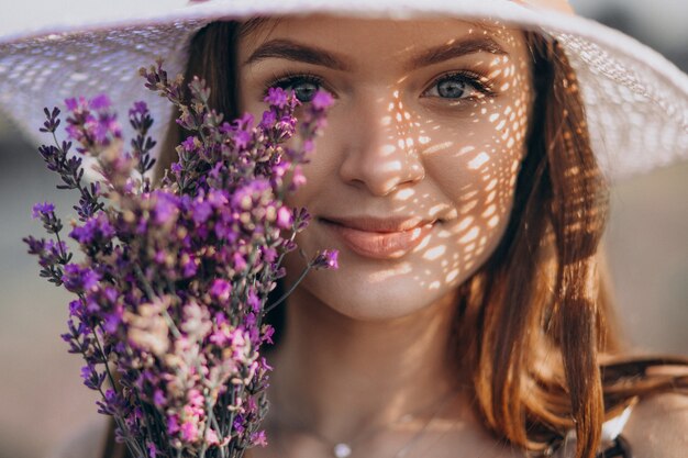 Bella donna in abito bianco in un campo di lavanda