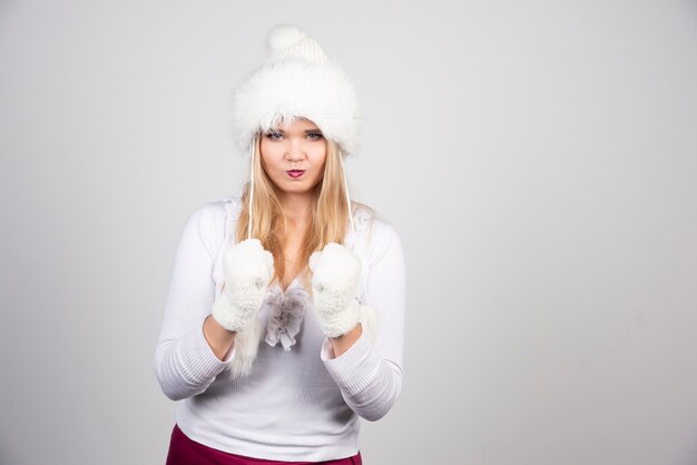 Bella donna in abito invernale che gioca con il cappello.