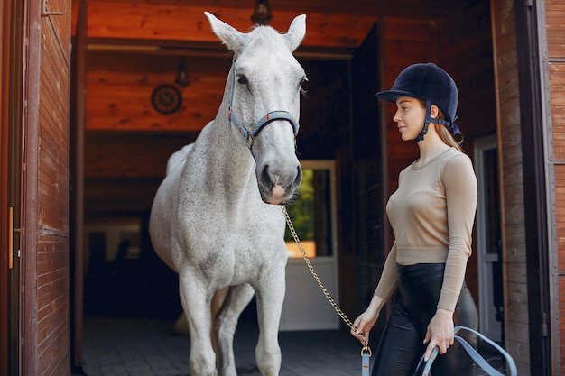 Bella donna in piedi con un cavallo