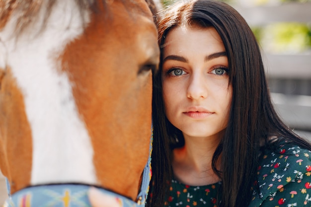 Bella donna in piedi con un cavallo