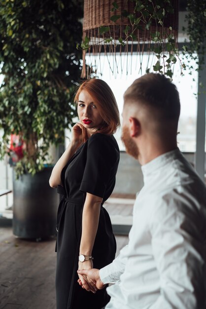 Bella donna in un abito nero e un uomo in una camicia bianca.