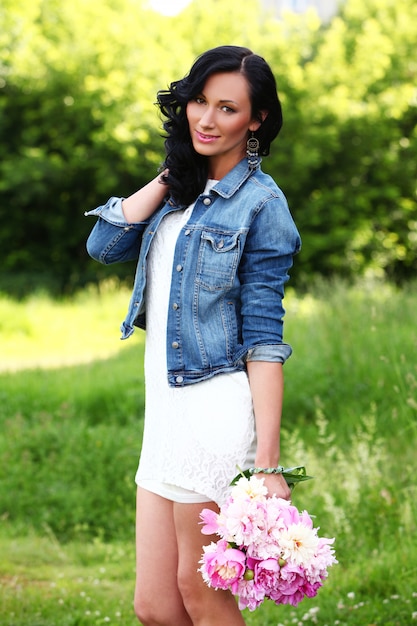 Bella donna in un parco con bouquet