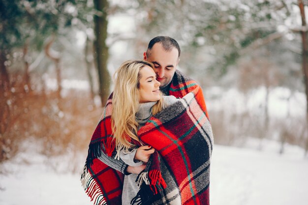 Bella donna in un parco d'inverno con suo marito