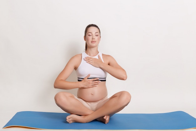 Bella donna incinta che fa yoga a casa