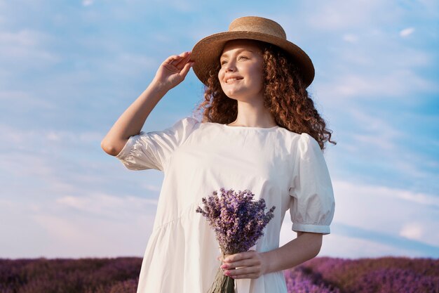 Bella donna nella priorità bassa del campo di lavanda