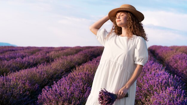 Bella donna nella priorità bassa del campo di lavanda