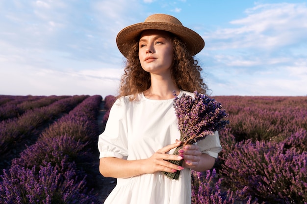 Bella donna nella priorità bassa del campo di lavanda