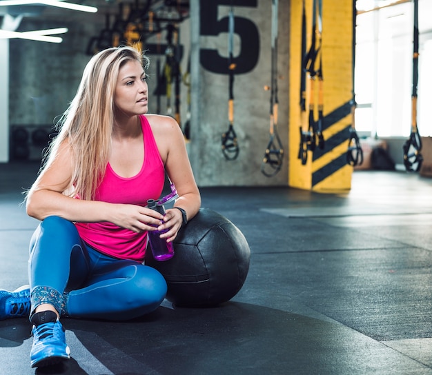 Bella donna rilassante dopo aver terminato l&#39;allenamento in palestra