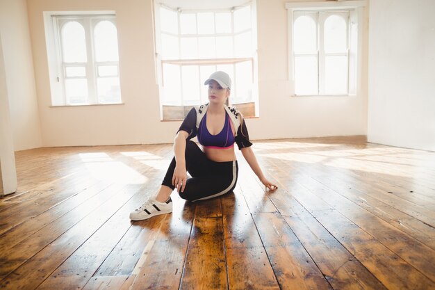 Bella donna seduta in studio di danza hip-hop