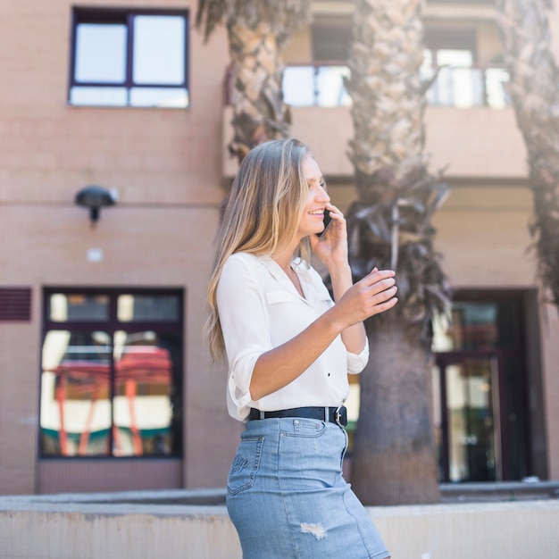 Bella donna sorridente che parla sul telefono cellulare