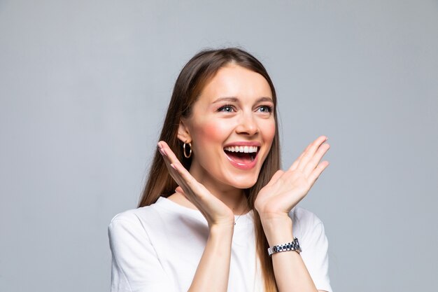 Bella donna sorridente con la bocca aperta e le palme aperte isolate