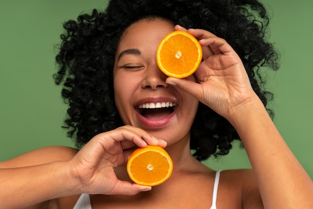 Bella donna sorridente mentre si tiene arance