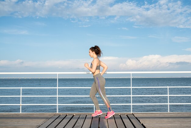 Bella donna sportiva jogging sul ponte