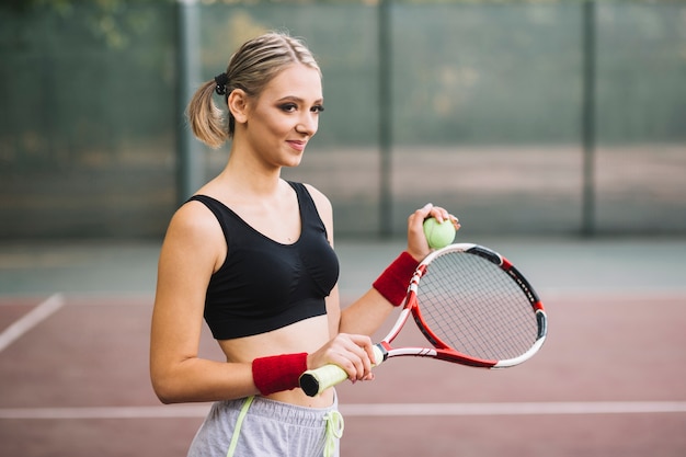 Bella donna sul gioco del campo da tennis