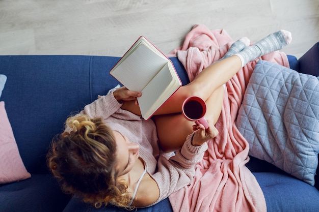 Bella donna sulla lettura del divano