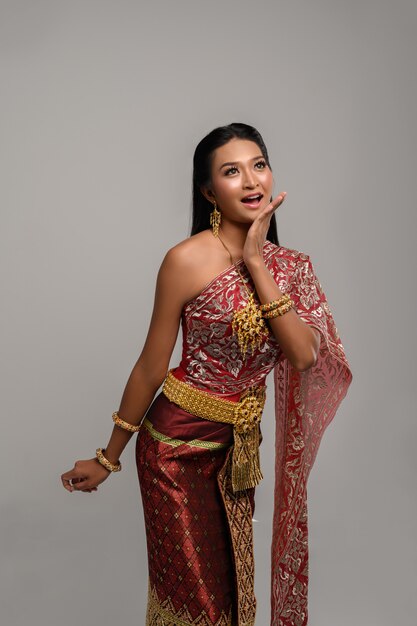 Bella donna tailandese che porta vestito tailandese e che esamina la cima