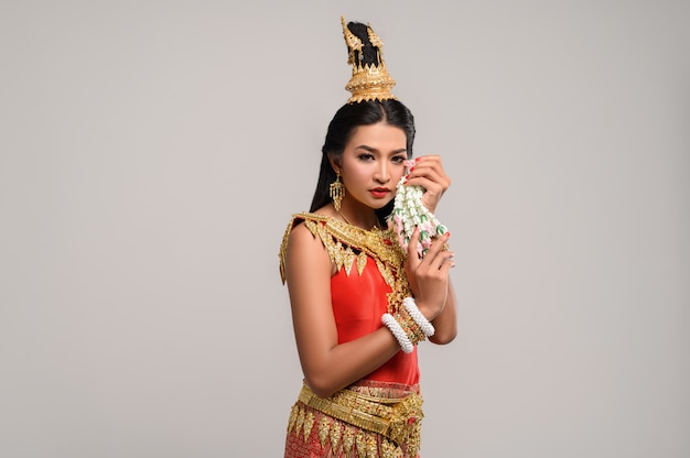 Bella donna tailandese che porta vestito tailandese e che guarda al lato