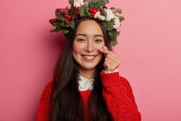 Bella e giovane donna che indossa la corona di Natale sulla sua testa