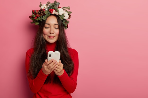 Bella e giovane donna che indossa la corona di Natale sulla sua testa