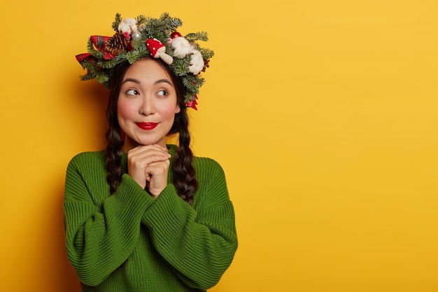 Bella e giovane donna che indossa la corona di Natale sulla sua testa