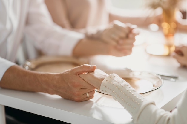 Bella famiglia che prega prima di mangiare il primo piano