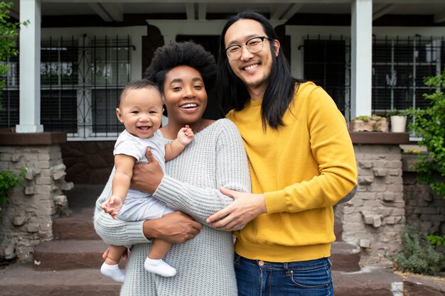 Bella famiglia multietnica in piedi sotto il portico durante il blocco covid19