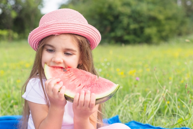 Bella fetta di anguria mangiare seduto nel parco