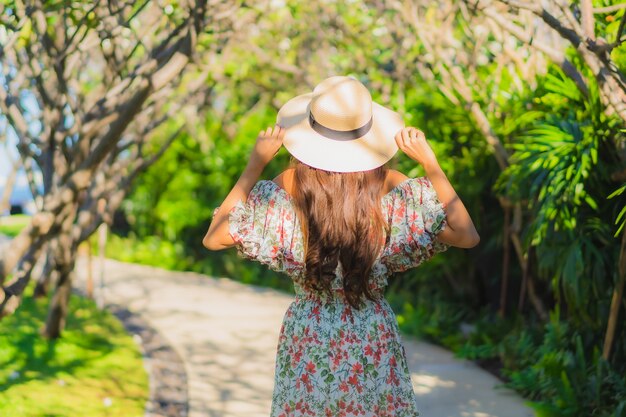 Bella giovane donna asiatica del ritratto che cammina con felice intorno alla vista all'aperto del giardino