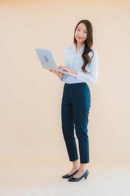 Bella giovane donna asiatica del ritratto con il computer portatile del computer per lavoro