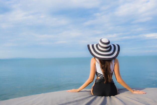 Bella giovane donna asiatica del ritratto intorno all'oceano della spiaggia del mare