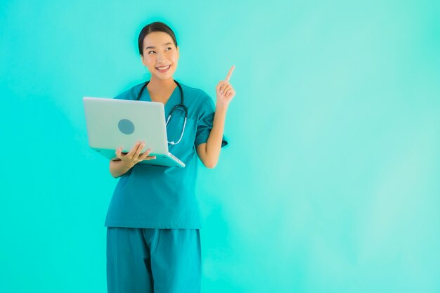 Bella giovane donna asiatica di medico del ritratto con il computer portatile o il computer