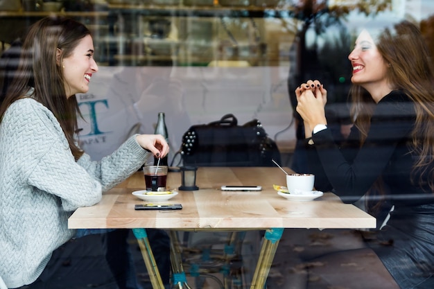 Bella giovane donna bere il tè in un negozio di caffè.