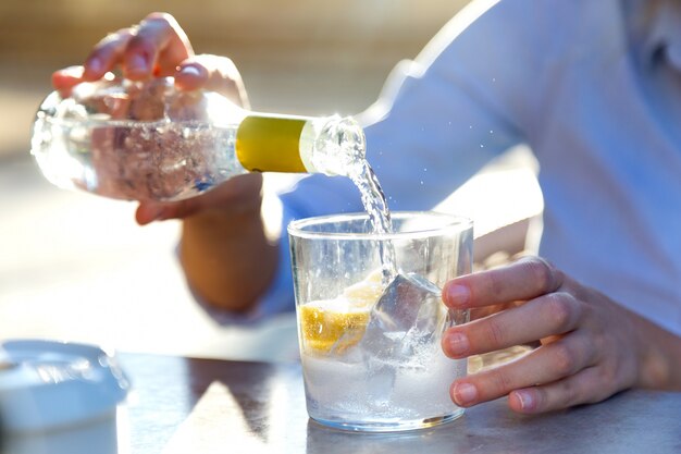 Bella giovane donna beve soda in una terrazza del ristorante.