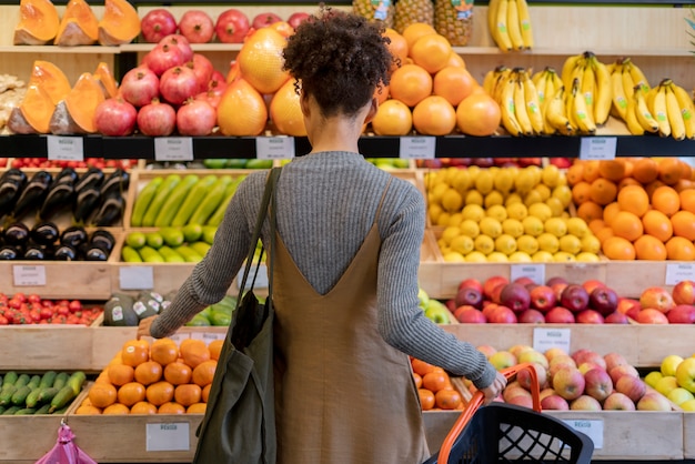 Bella giovane donna che fa la spesa per il cibo