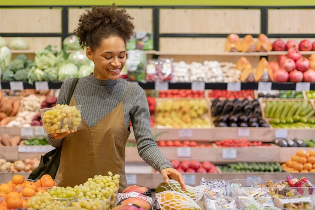 Bella giovane donna che fa la spesa per il cibo